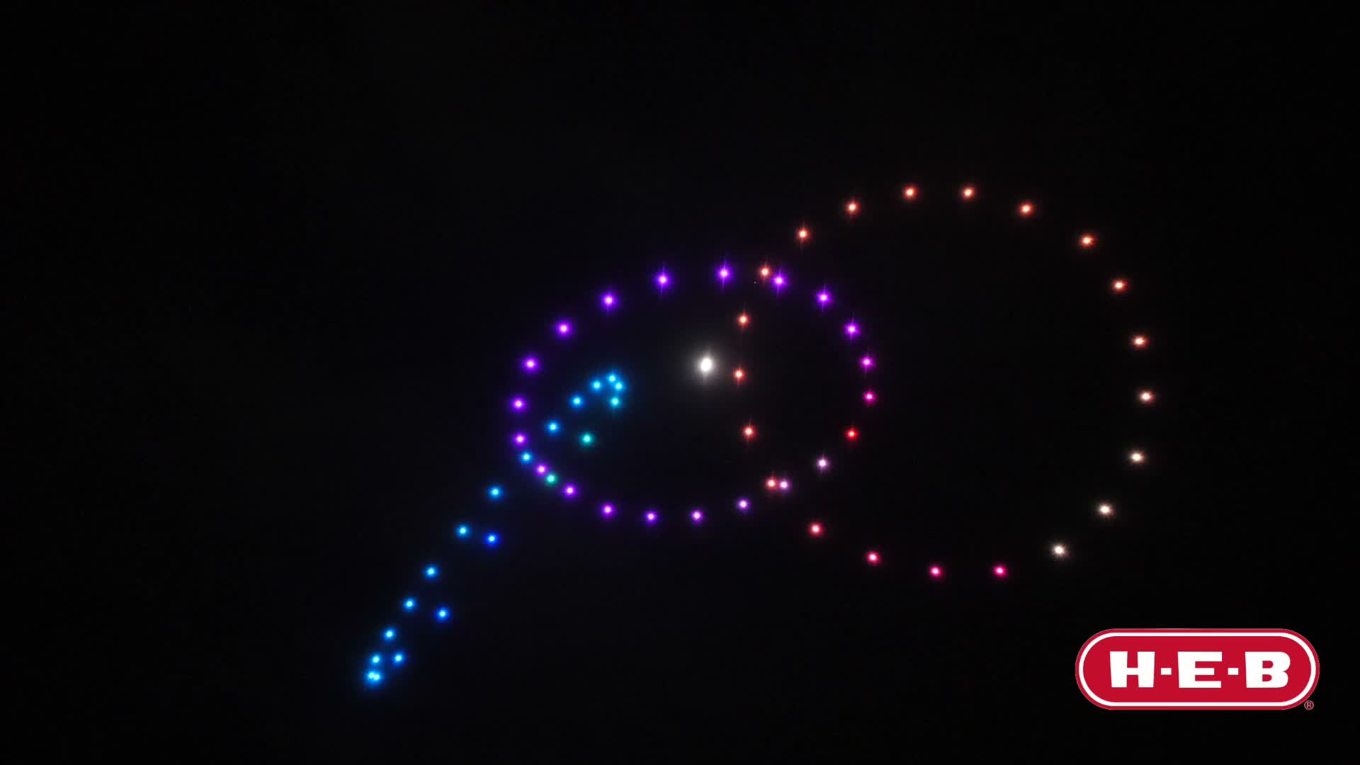 Enjambre de drones de luz formando una figura en el cielo nocturno